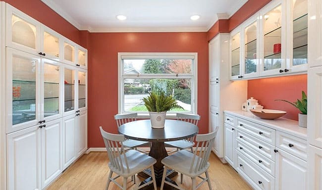 Seattle terracotta color eating nook with white cabinets