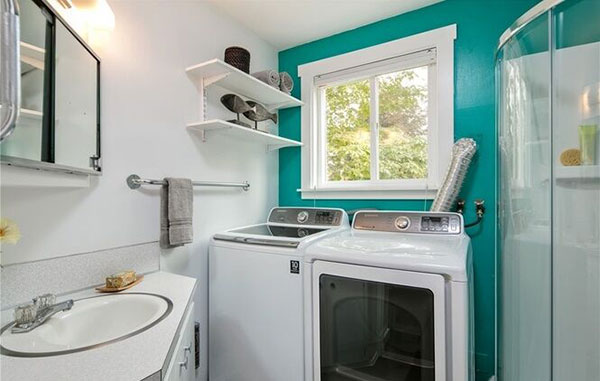 Teal color accent wall in laundry room design
