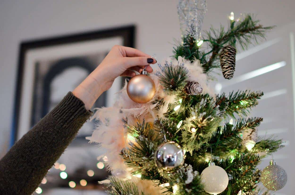 Person decorating a christmas tree