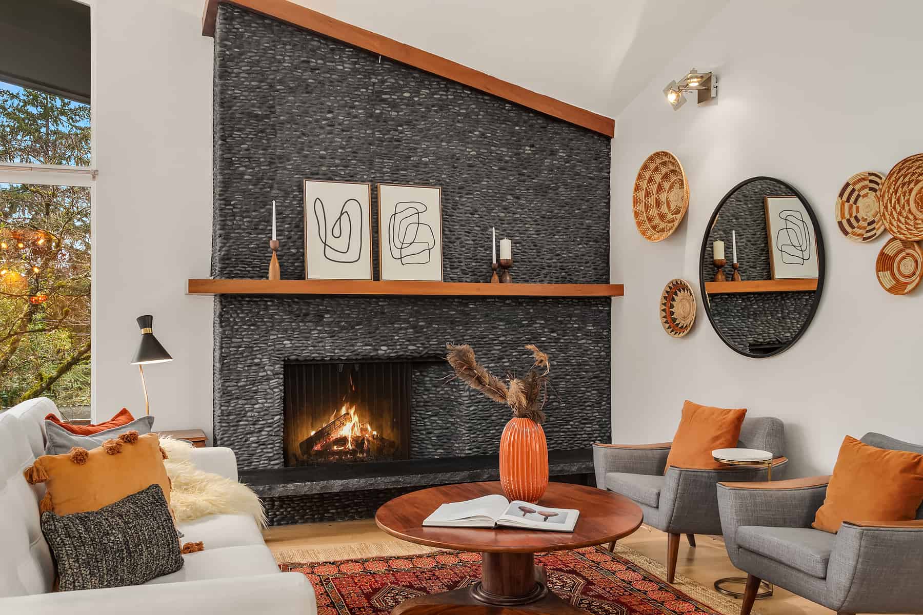 midcentury living room with original stone fireplace and orange accents